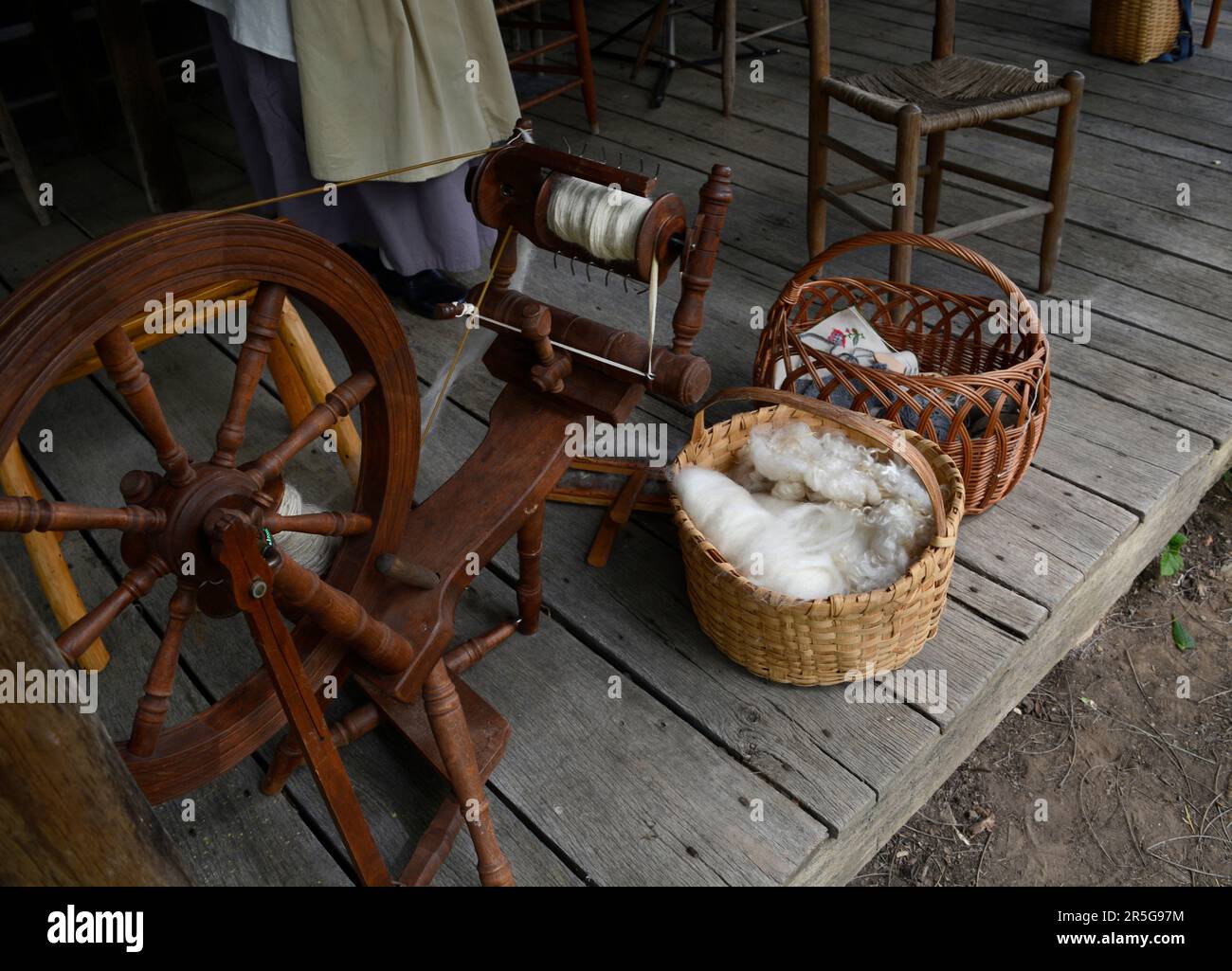 Cesti di lana cardata e altri tessuti sul portico del 19th ° secolo in legno cabina durante un evento di rievocazione storia vivente a Abingdon, Virginia. Foto Stock