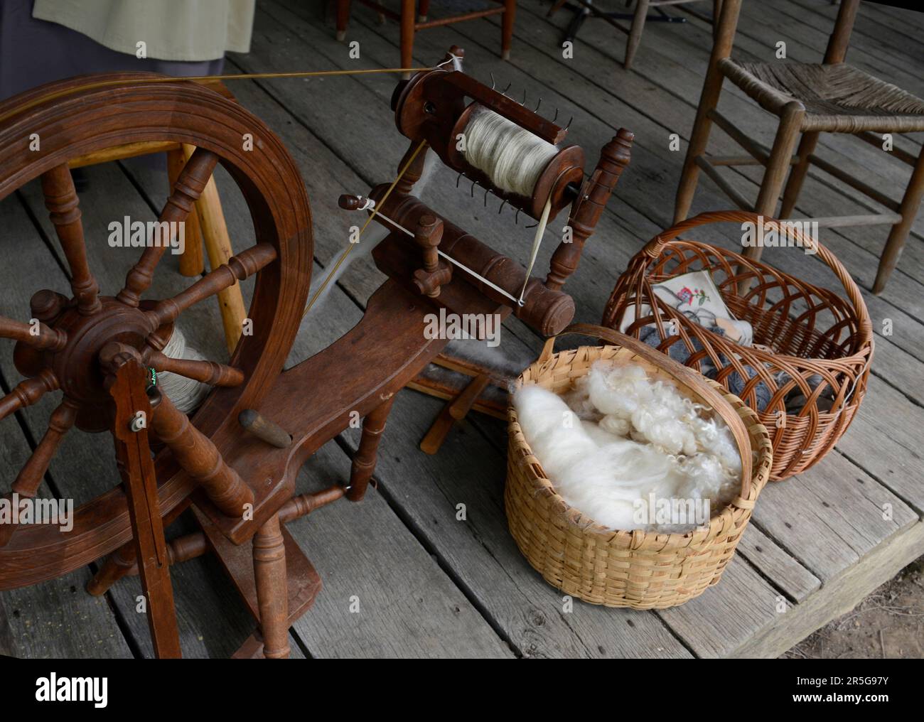 Cesti di lana cardata e altri tessuti sul portico del 19th ° secolo in legno cabina durante un evento di rievocazione storia vivente a Abingdon, Virginia. Foto Stock