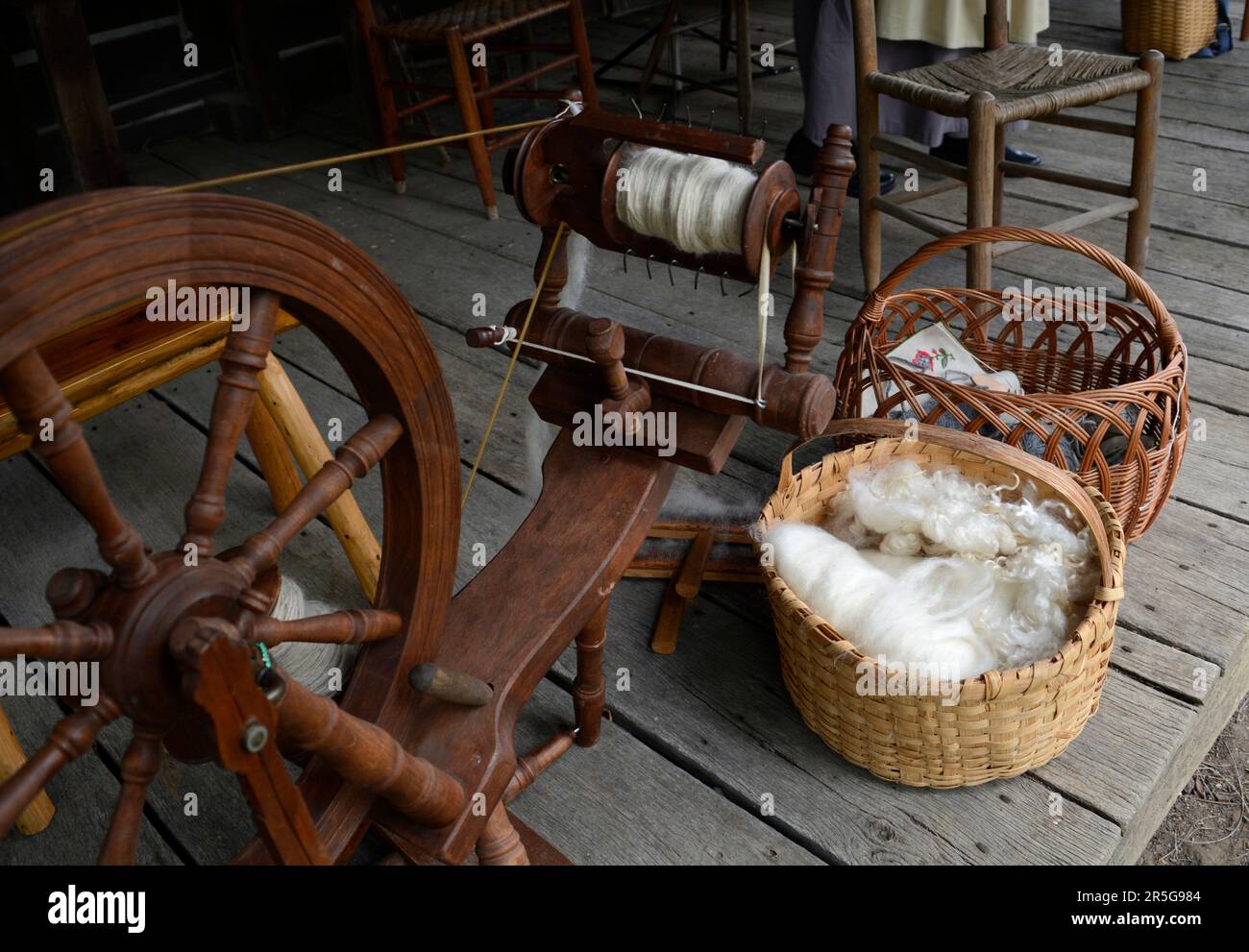 Cesti di lana cardata e altri tessuti sul portico del 19th ° secolo in legno cabina durante un evento di rievocazione storia vivente a Abingdon, Virginia. Foto Stock