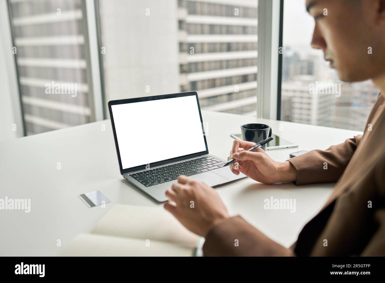 Uomo d'affari che lavora su un notebook, scherma in ufficio. Vista dall'alto Foto Stock