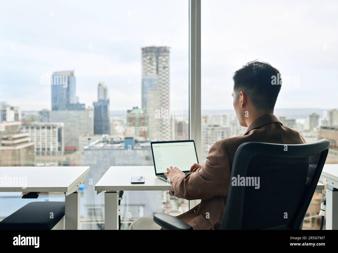 Uomo d'affari che lavora su un computer portatile in ufficio. Schermo bianco mock up Foto Stock