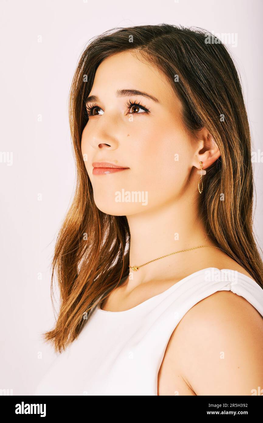 Primo piano ritratto di giovane bella donna su sfondo bianco, capelli castani, pelle perfetta, trucco morbido Foto Stock