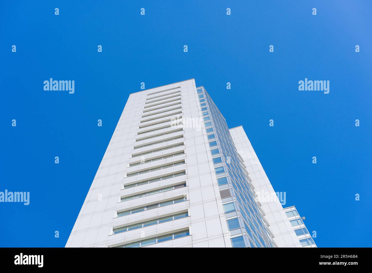 Riflessi di cristallo: Una facciata di edificio di granito grigio e pannelli di vetro scintillanti Foto Stock