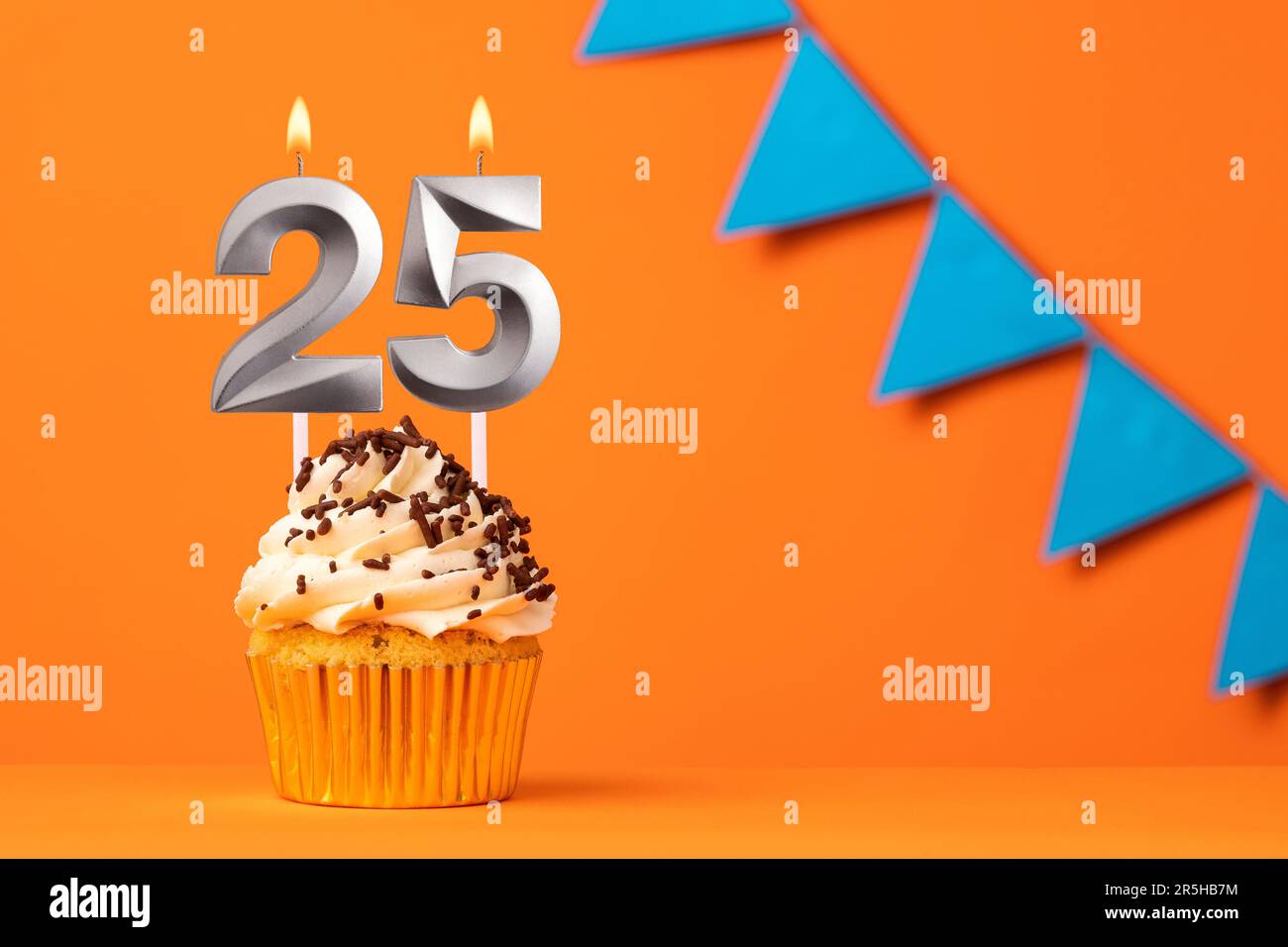 Candela numero 25 - compleanno torta su sfondo arancione Foto Stock