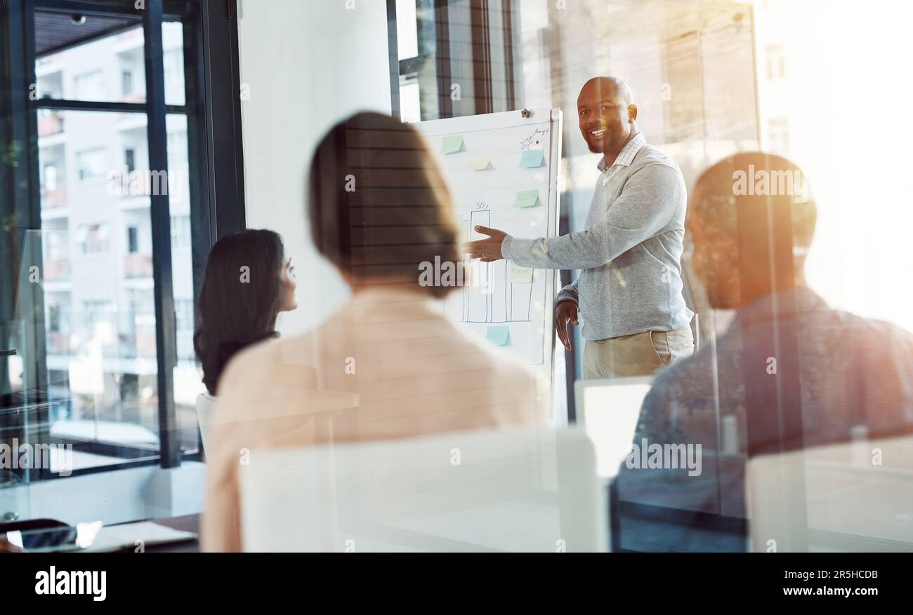 Comunicare una visione audace, specifica e coerente. Un uomo d'affari che dà una presentazione ai colleghi nella sala riunioni. Foto Stock