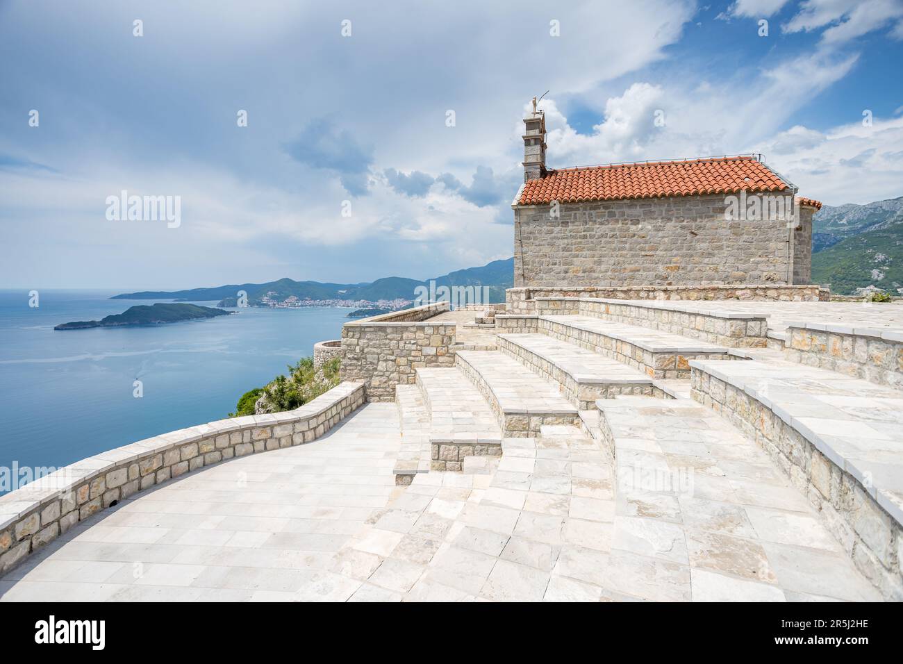 Chiesa di San Sava in alto su una montagna che domina Sveti Stefan visto di fronte alla Budva Riverira nel maggio 2023. Foto Stock