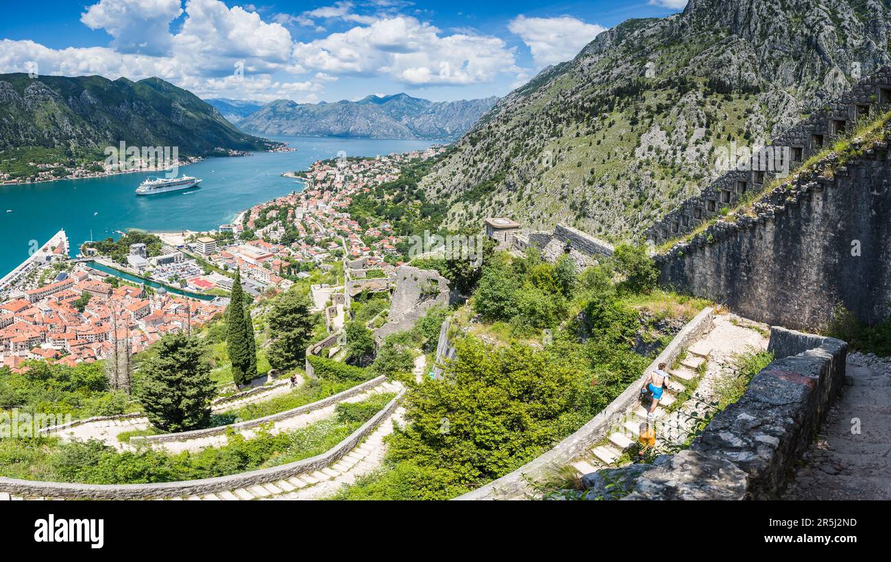 Le persone viste in una giornata calda nel maggio 2023 a piedi lungo la zig zag ripide gradini della scala di Cattaro in Montenegro. Foto Stock