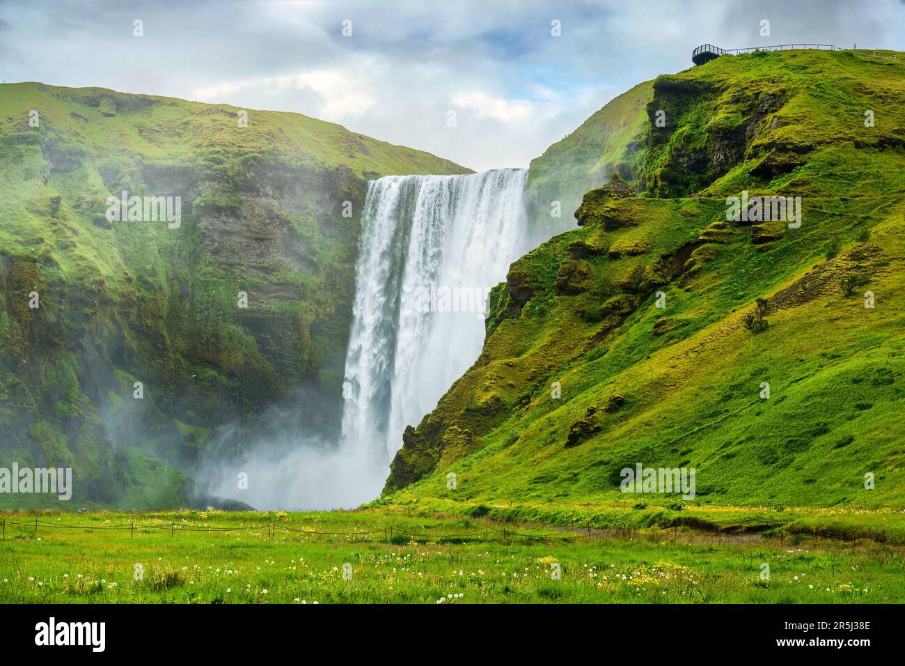 Splendido scenario della lussureggiante cascata Skogafoss che scorre in estate nel sud dell'Islanda Foto Stock