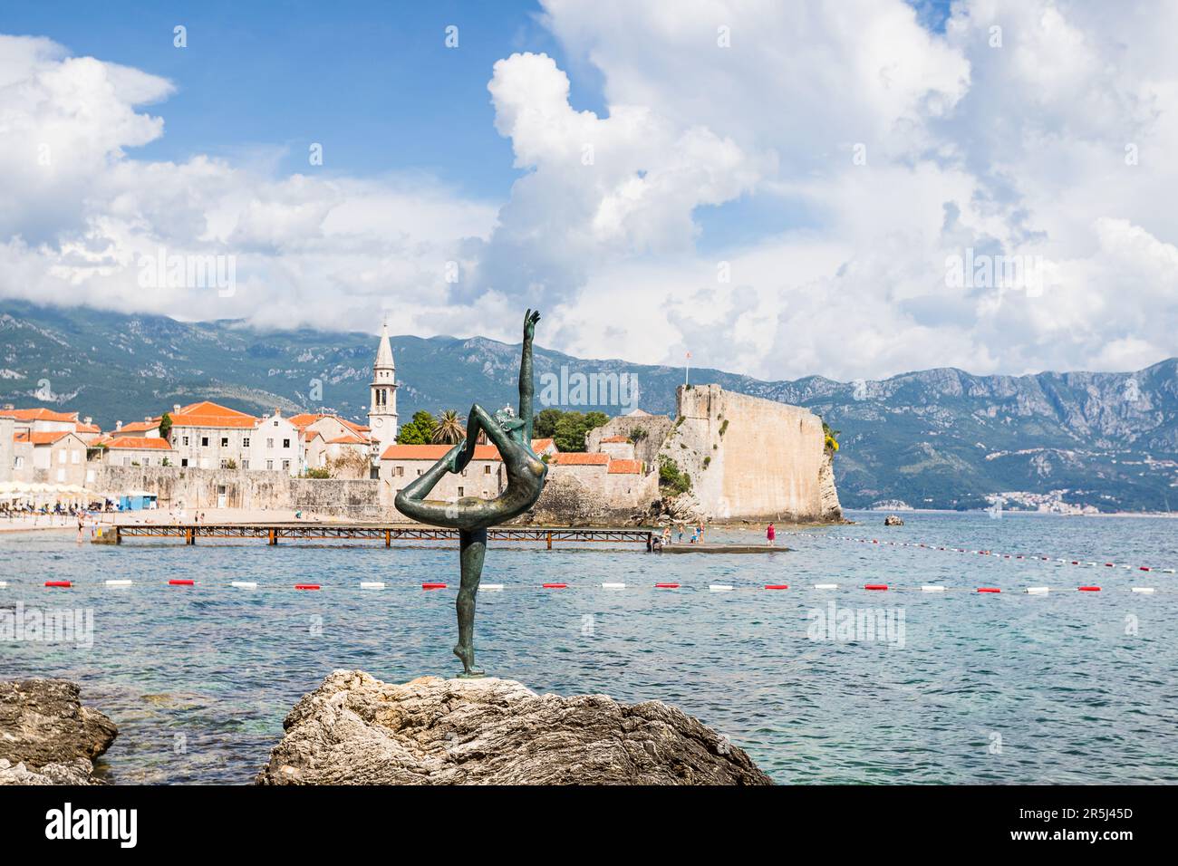 La statua di Budva ballerina raffigurata sulla cima di una roccia di fronte al centro storico di Budva nel maggio 2023. Creato da Gradimir Aleksic, lo scultore iconico Foto Stock