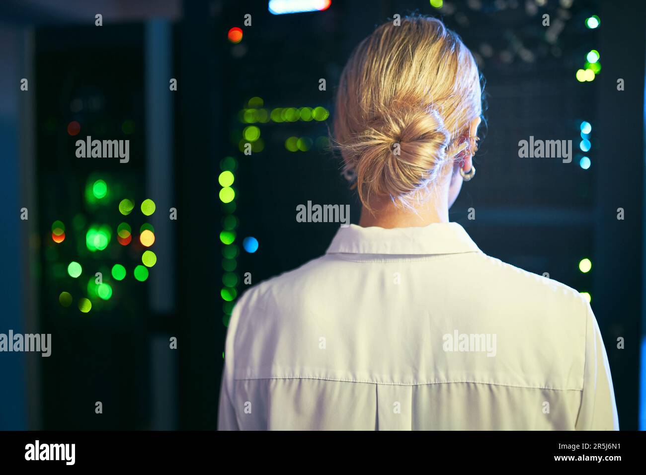 Ascoltare il ronzio dalle macchine. Uno specialista IT irriconoscibile che si trova da solo nella sala server. Foto Stock