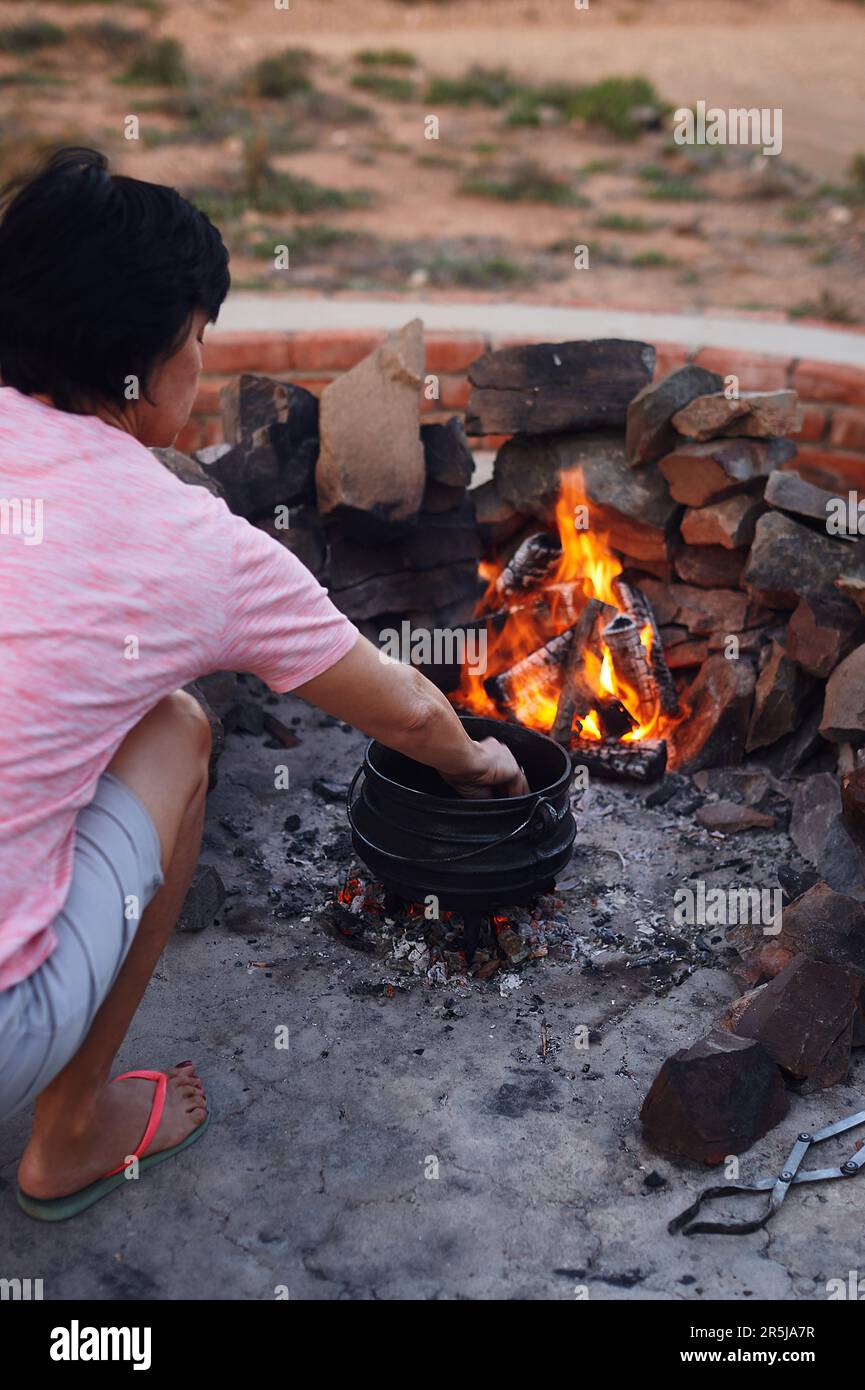 La cena di Tonights sarà una cena a cottura lenta. Una donna che cucina tradizionale sudafricano cibo da fuoco all'aperto. Foto Stock