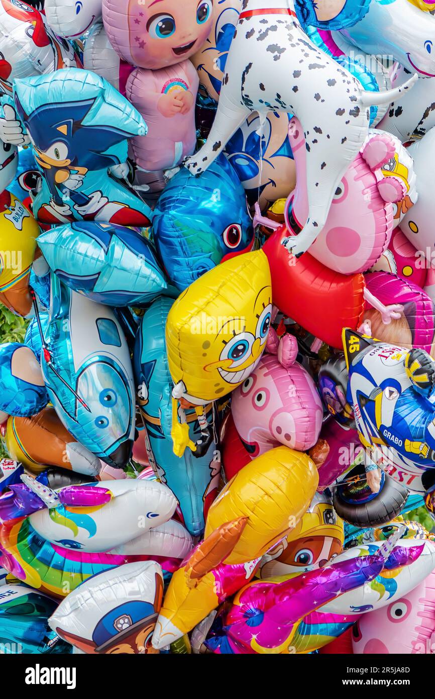 Zrenjanin, Serbia - 29 aprile 2023: Un mazzo di palloncini di elio con vari personaggi famosi dei cartoni animati per bambini sul mercato di strada Foto Stock