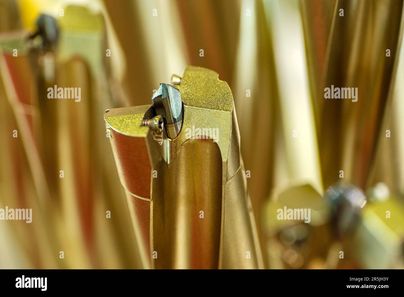 Punta elicoidale per utensili da lavorazione metalli, primo piano con bellissimo sfondo sfocato dorato, astratto industriale Foto Stock