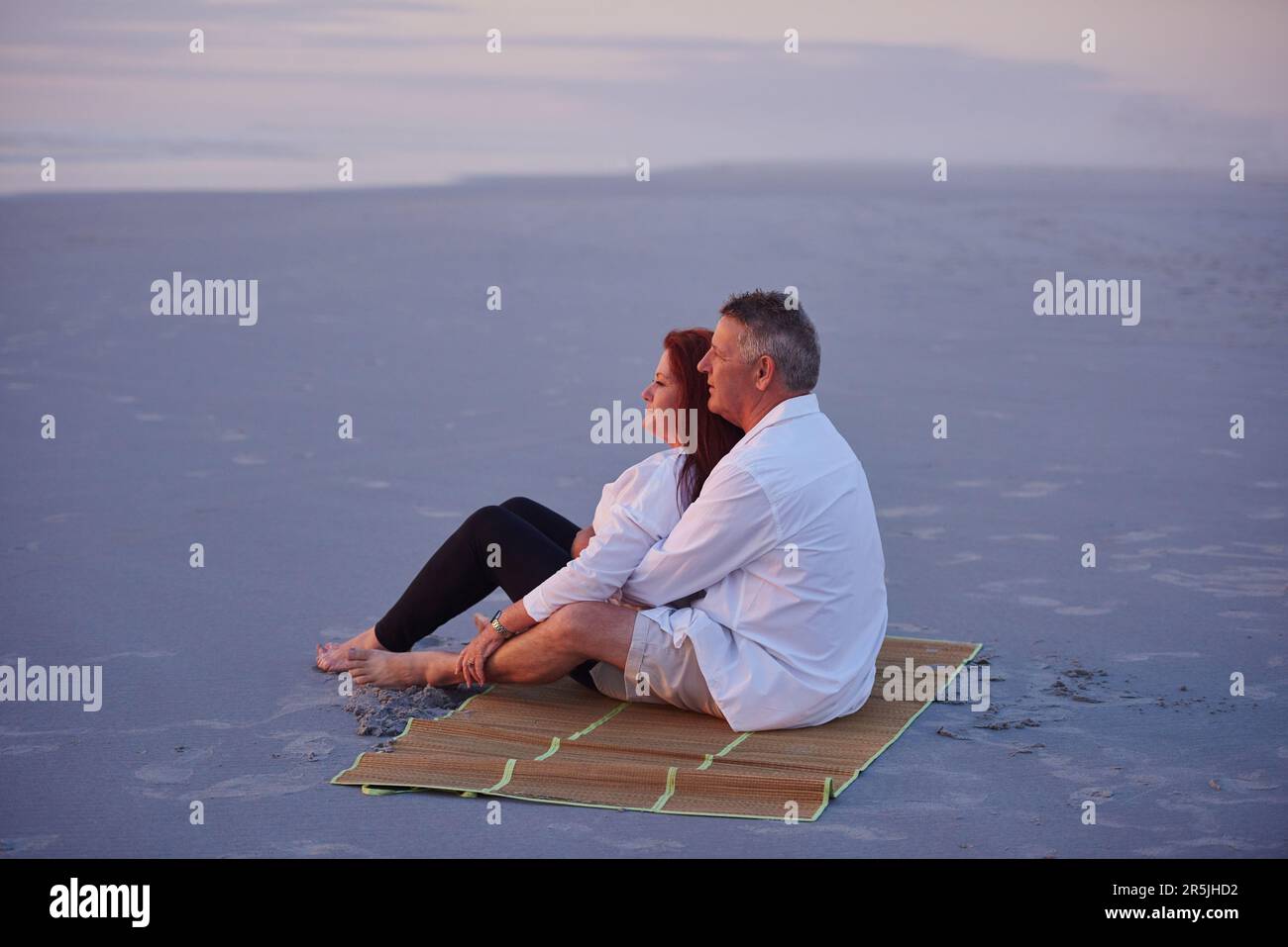 Vivere la vita nella corsia lenta. una coppia matura che si rilassa insieme sulla spiaggia. Foto Stock