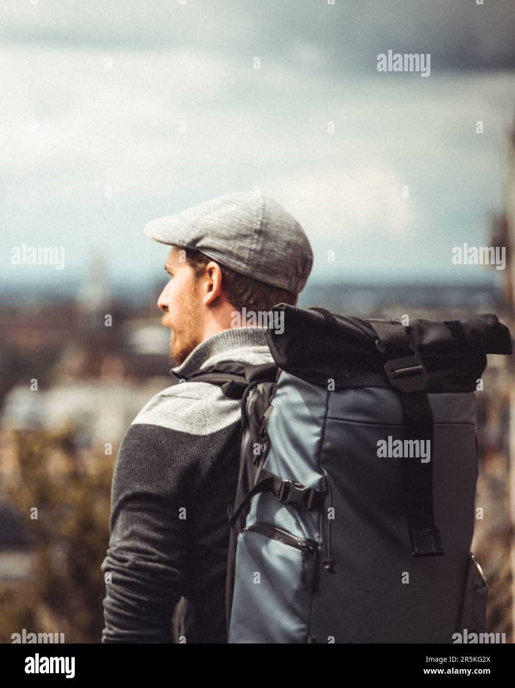 In un punto panoramico che si affaccia su Edimburgo, una persona colpisce una posa, catturando l'essenza della vibrante città. Sullo sfondo di un landmar iconico Foto Stock