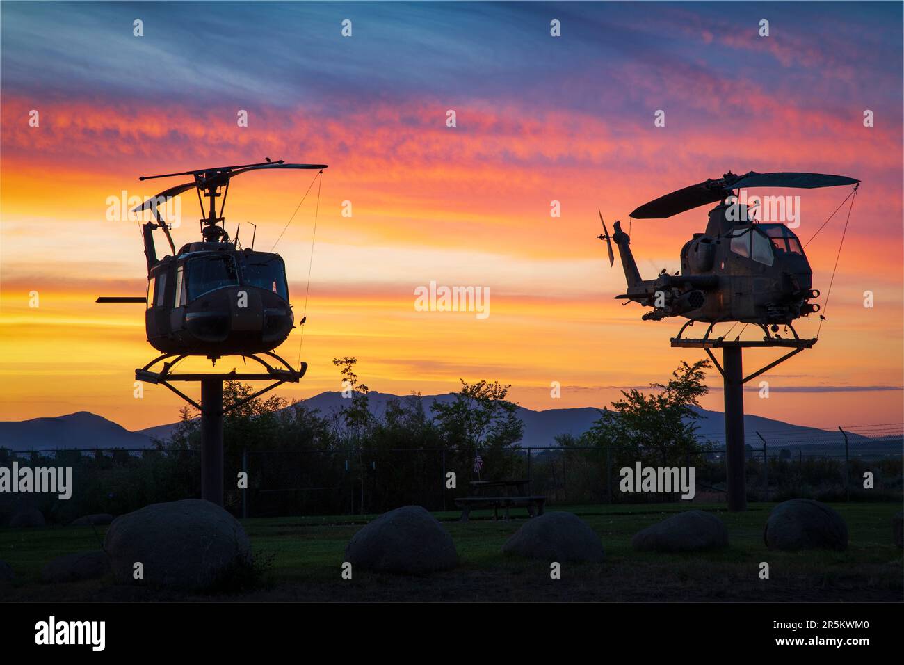 Ritirati UH-1 Iroquois ('Huey') e AH-1 Cobra Elicotters prima di vibranti colori alba presso l'aeroporto municipale di Susanville - Lassen County CA, USA. Foto Stock