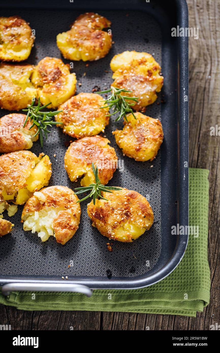 Patate al forno o arrosto in vassoio di metallo condito con rosmarino e sale e pepe. Dorato e croccante. Foto Stock