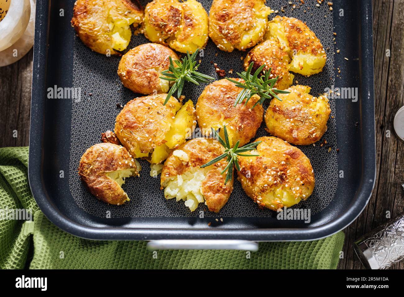 Patate al forno o arrosto in vassoio di metallo condito con rosmarino e sale e pepe. Dorato e croccante. Foto Stock