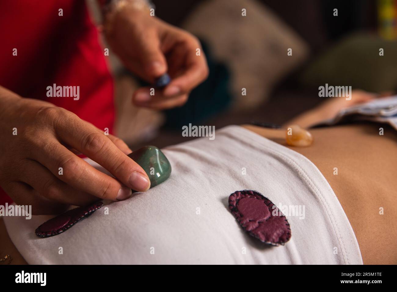 giovane donna sdraiata sul lettino da massaggio che riceve terapia olistica con magneti e quarzo, fotografia di dettaglio, terapia biomagnetistica medica, Foto Stock