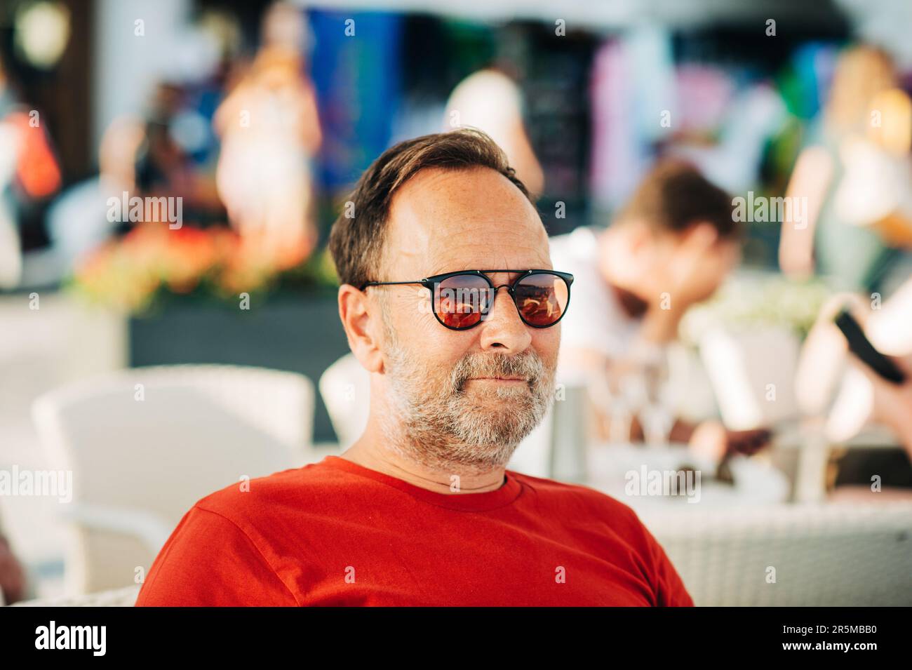 Ritratto all'aperto di un uomo di 50 anni che indossa una t-shirt rossa e occhiali da sole Foto Stock