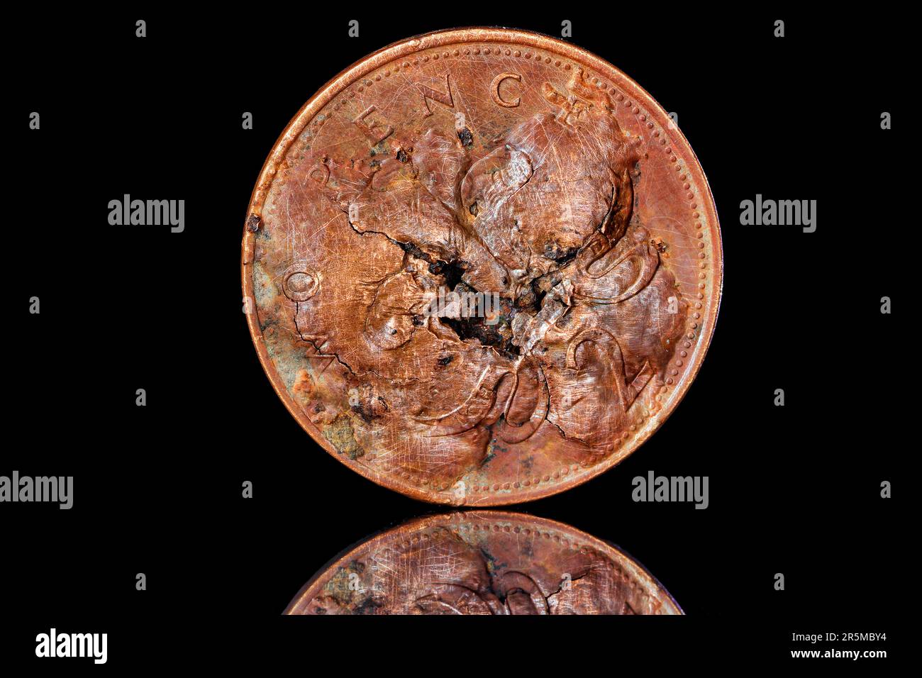 Una moneta da 2 pence danneggiata che presenta vesciche sul lato opposto Foto Stock