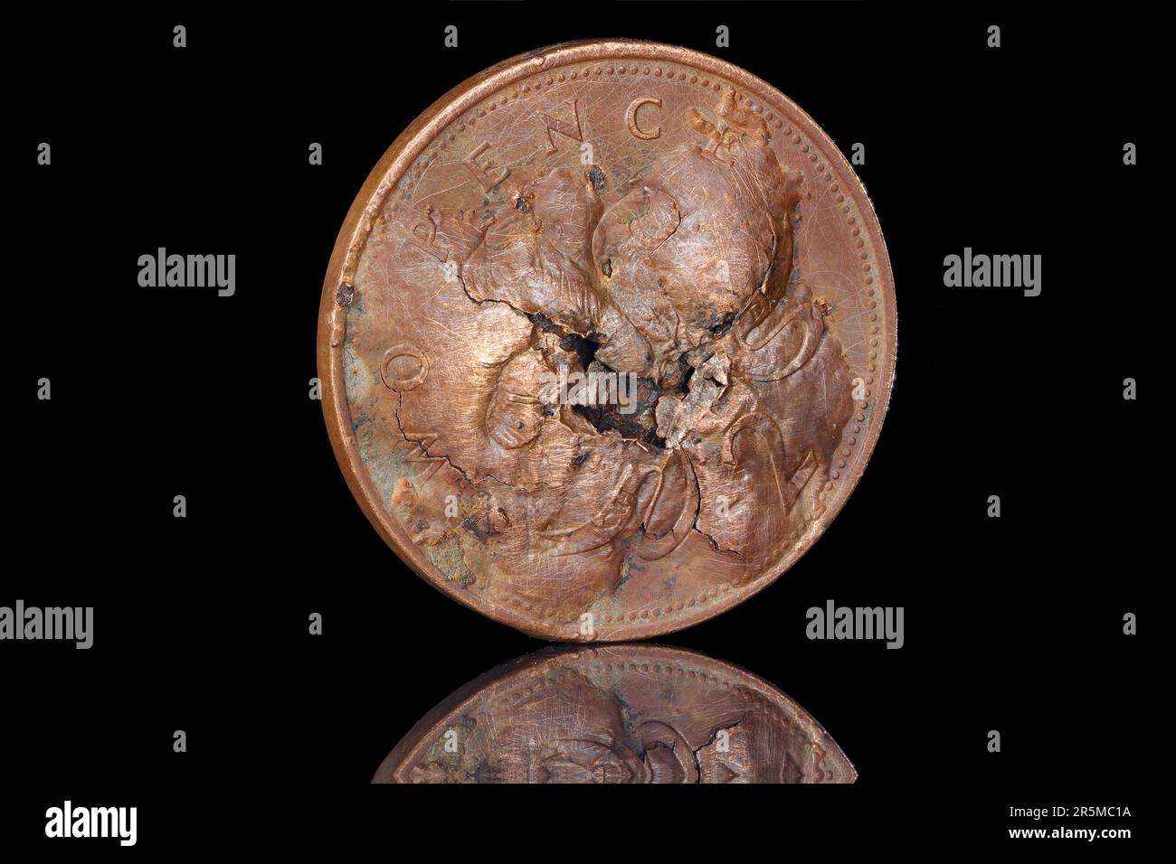 Una moneta da 2 pence danneggiata che presenta vesciche sul lato opposto Foto Stock