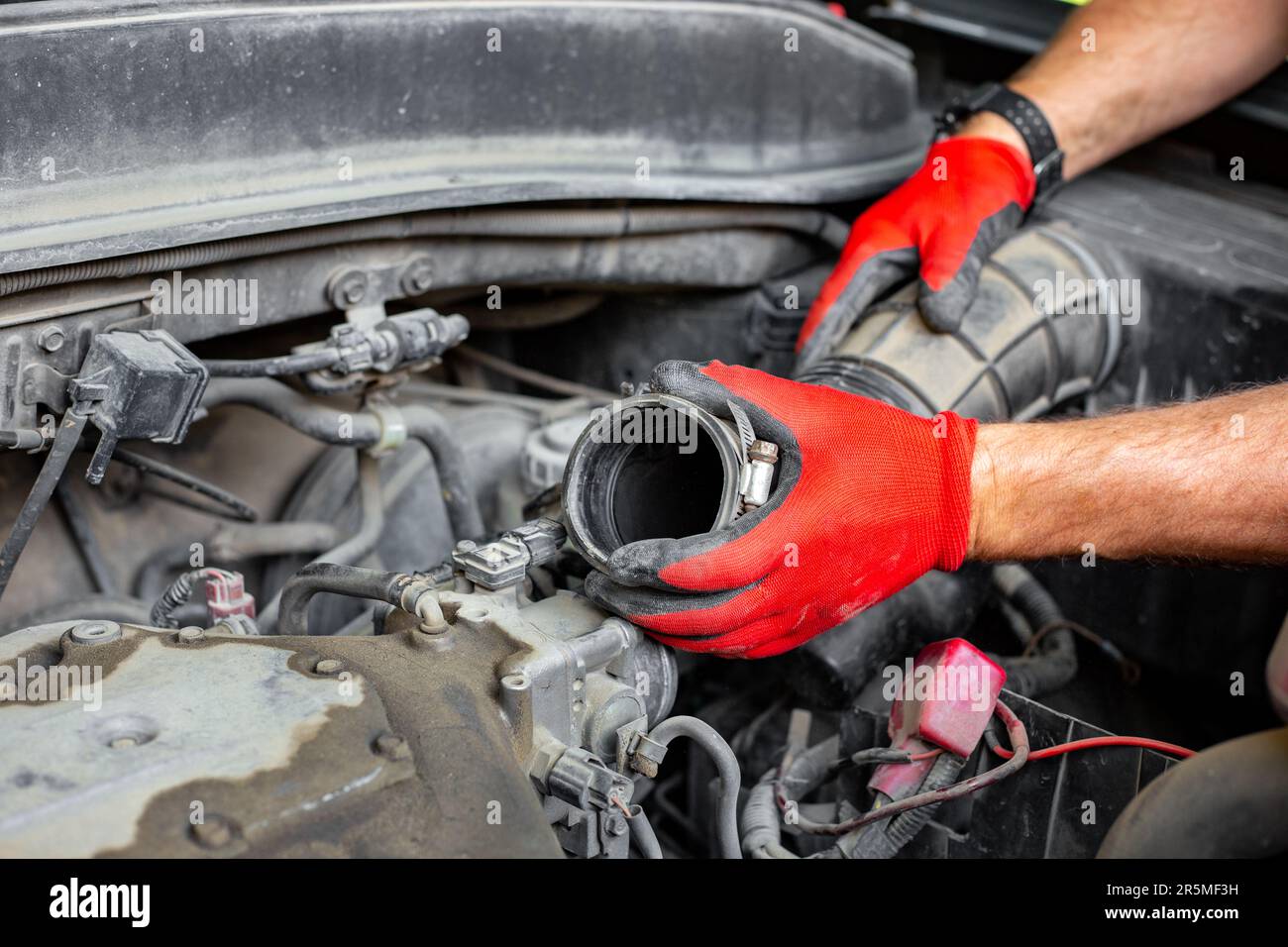 Il meccanico dell'auto ha scollegato il tubo dell'aria dal motore dell'auto. Riparazioni auto. Foto Stock