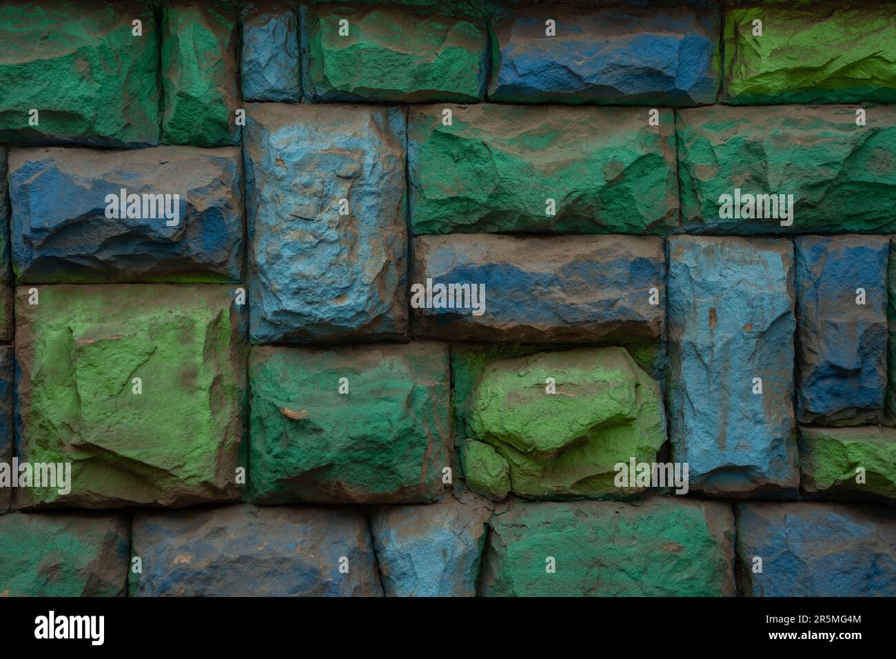 Una foto colorata verde e blu muro di pietra, sfondo, texture. Foto Stock