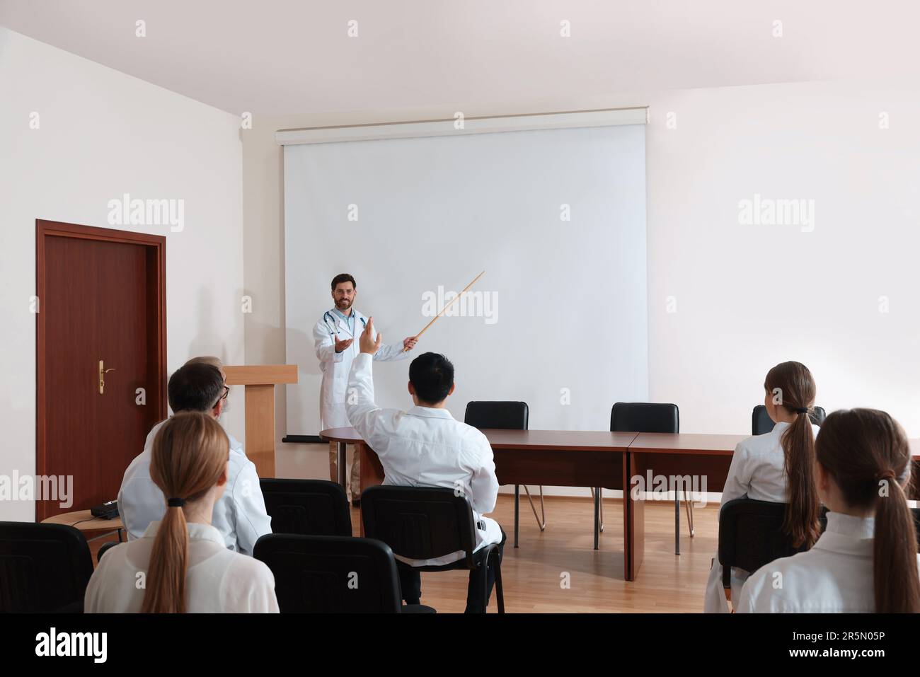 Dottore in conferenza in sala conferenze con schermo di proiezione Foto Stock
