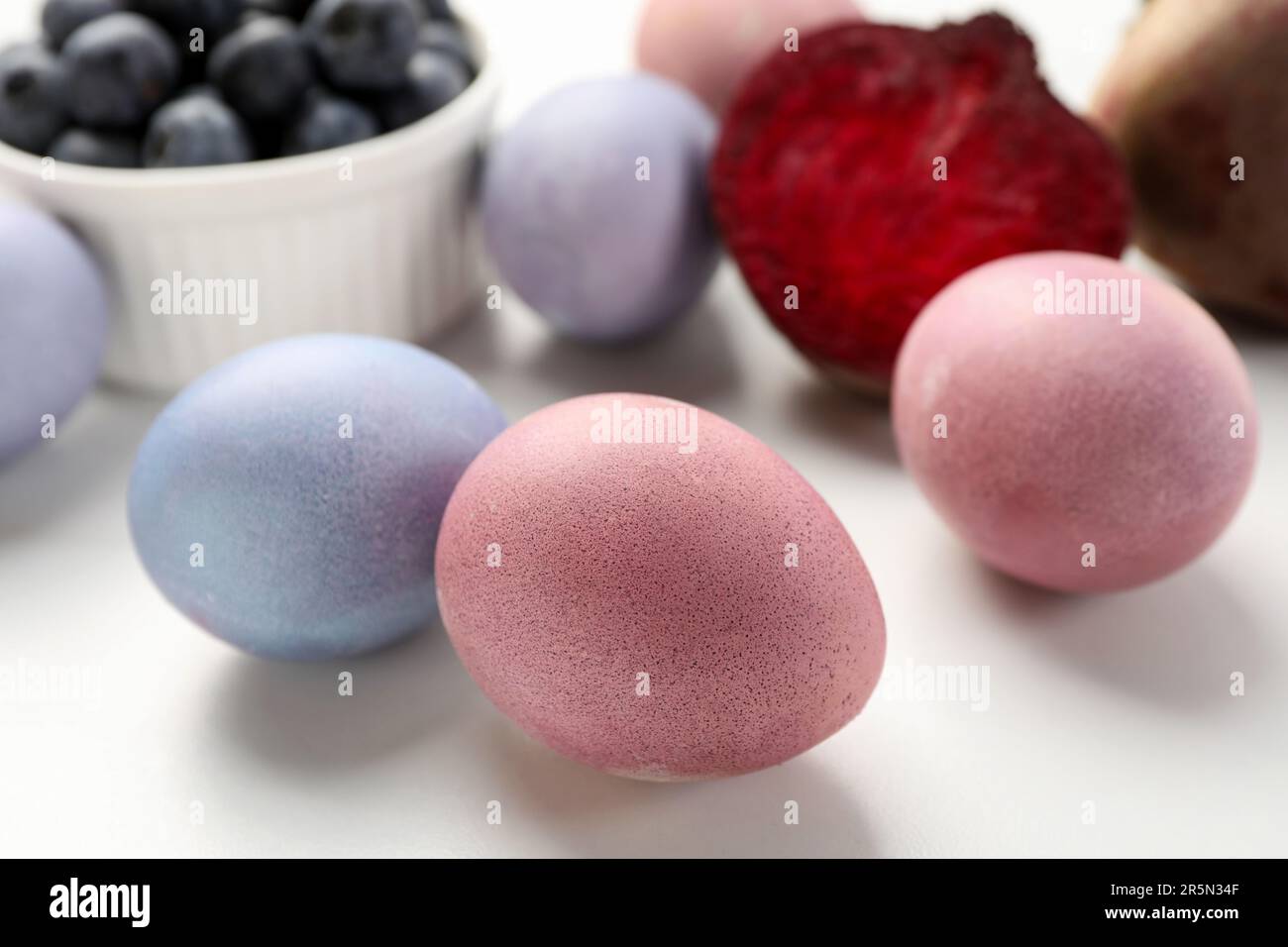 Colorate uova di Pasqua dipinte con coloranti naturali su tavola bianca, primo piano Foto Stock