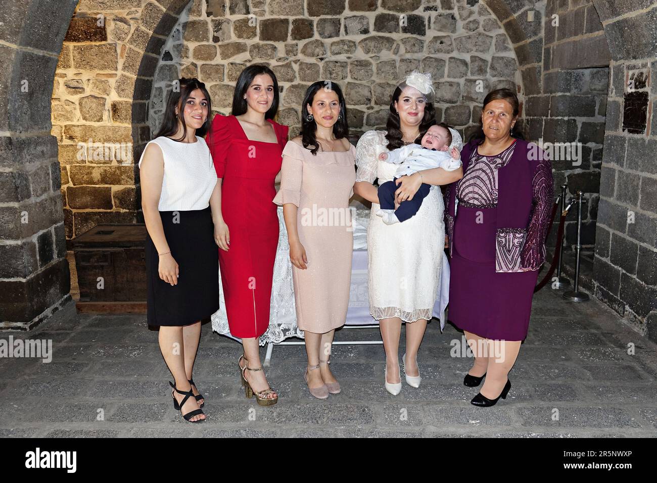 Diyarbakir, Turchia. 04th giugno, 2023. Madre Hulya Karadayi è visto scattare una foto con i parenti prima del battesimo. La cerimonia del battesimo dei figli di Mushe Akbulut e Hulya Karadayi si tenne presso l'antica chiesa siriaca della Vergine Maria di Diyarbak?r secondo le tradizioni siriache. Poiché il numero di assiri che vivono a Diyarbakir è così decaduto, Mushe e Hulya sono diventati i primi assiri a sposarsi dopo una pausa di 40 anni. I figli della famiglia erano guidati dal sacerdote Gabriel Akyuz, che proveniva dalla città di Mardin per il rituale tenuto nella Chiesa della Vergine Maria. Credit: SOPA Images Limited/A. Foto Stock