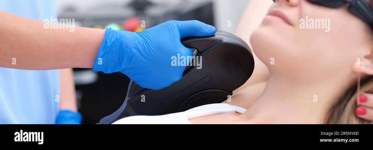 L'estetista fa la procedura di rimozione dei capelli del laser nella zona  delle ascelle della giovane donna in clinica. Procedura di rimozione dei peli  con fotoepilatore o laser Foto stock - Alamy