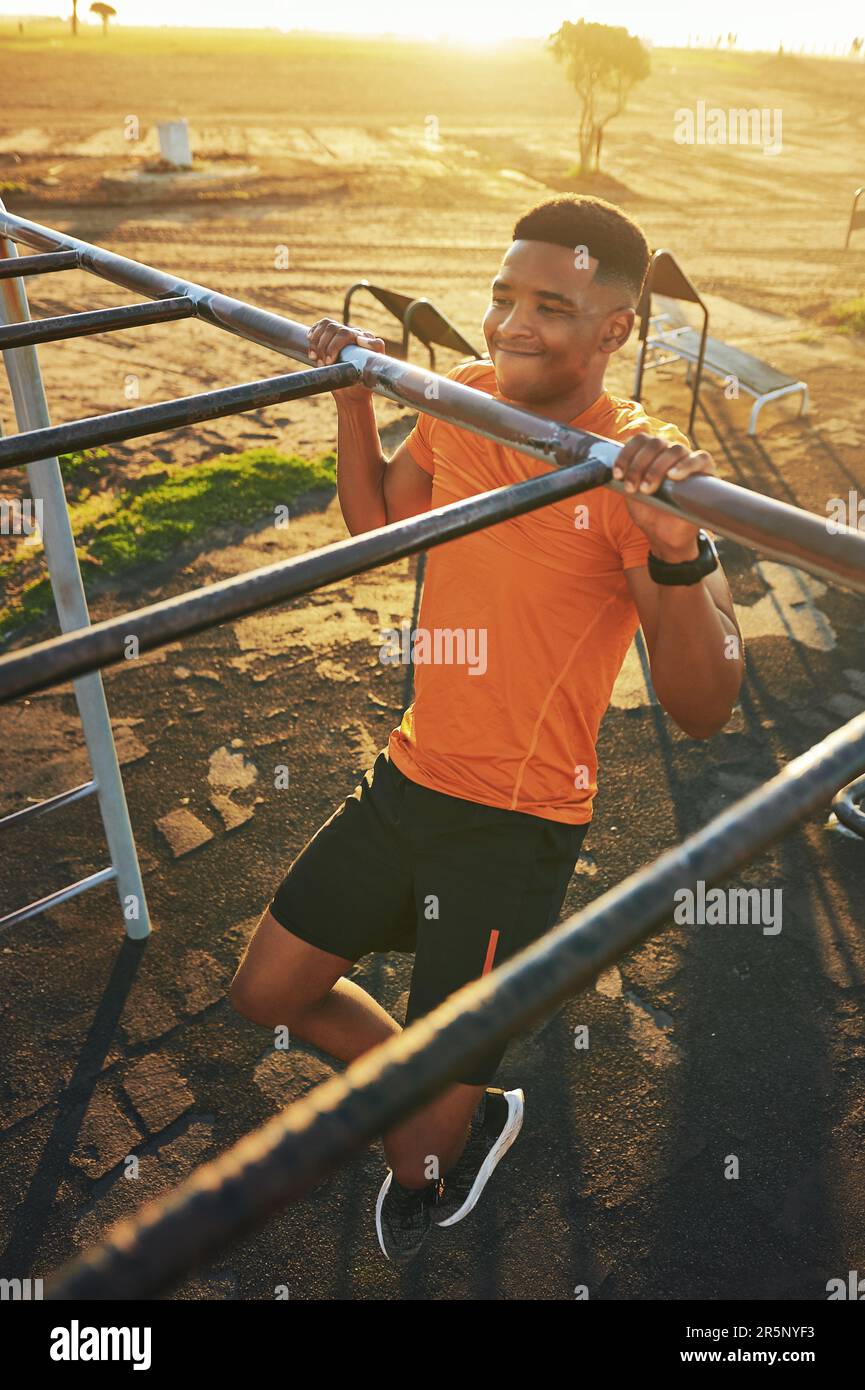 Il mio corpo dice di no, ma la mia mente dice di sì. un giovane uomo che si allenava nella palestra all'aperto del parco. Foto Stock