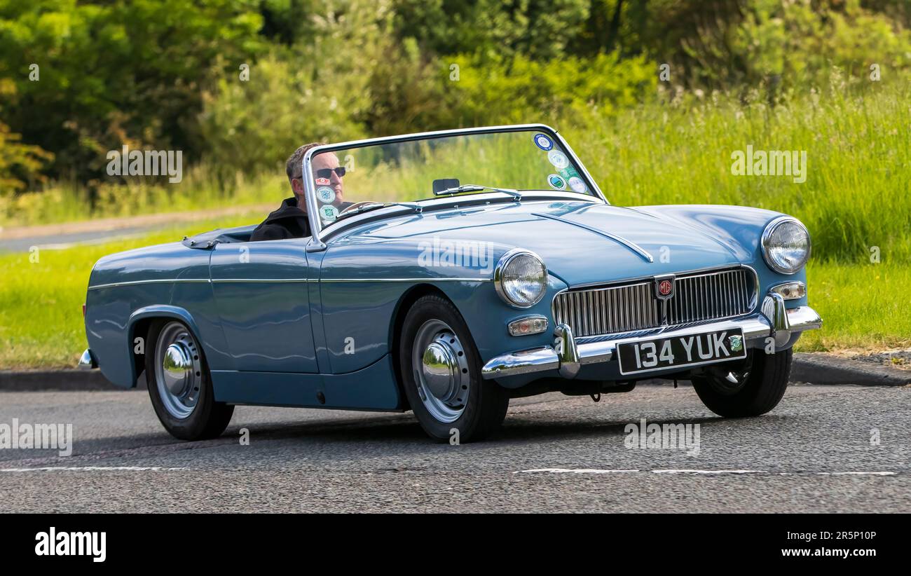 Stony Stratford, Regno Unito - Giugno 4th 2023: 1961 blu MG MIDGET auto classica in viaggio su una strada di campagna inglese. Foto Stock