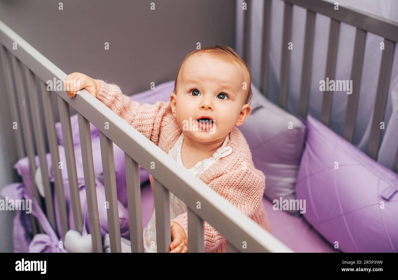 Ritratto di adorabile bambina che gioca in grey grey grey con lettiera viola Foto Stock