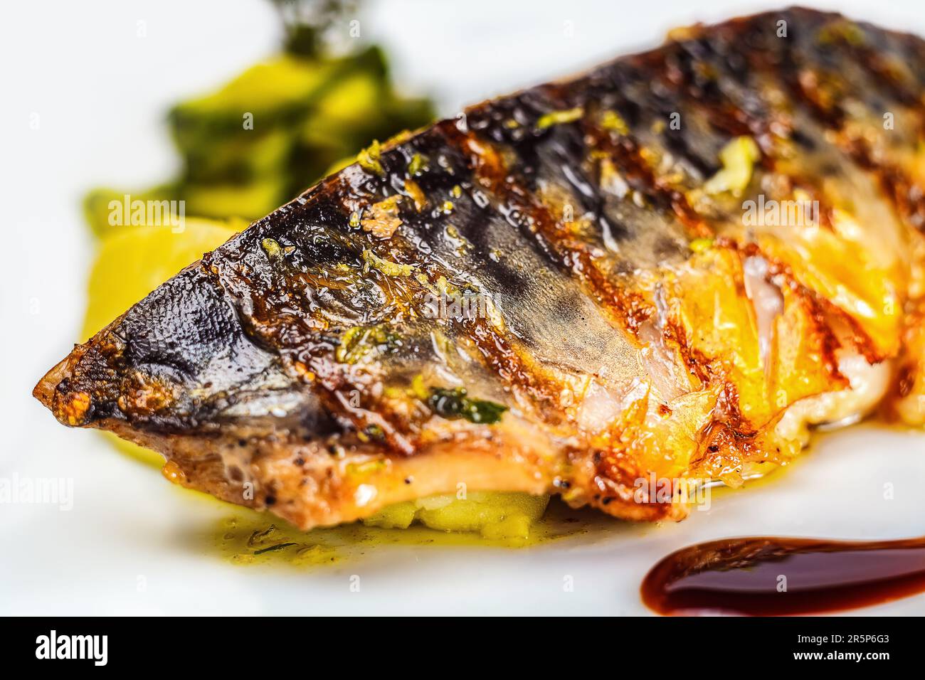Un delizioso piatto di pesce appena grigliato al barbecue, un pasto sano e gustoso su un piatto per cena. Foto Stock