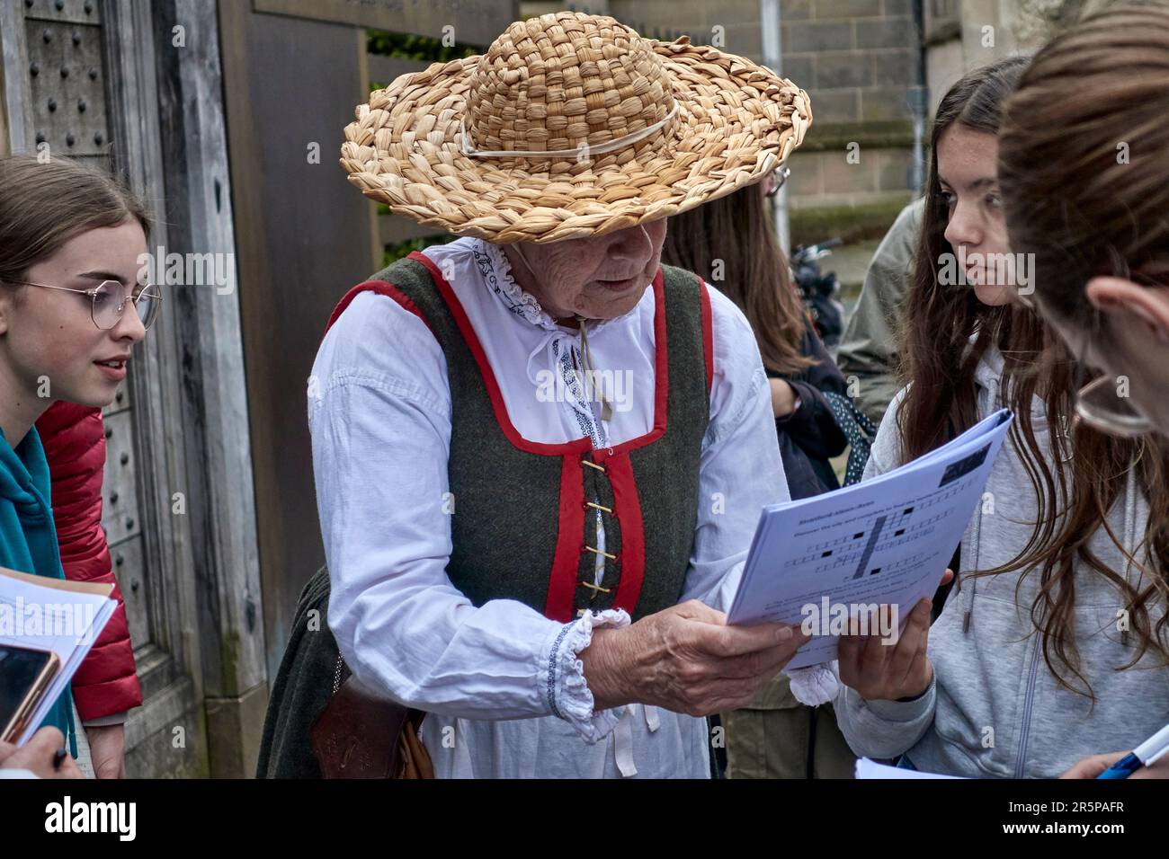 Guida turistica del Regno Unito. Donna in costume Tudor tradizionale con studenti stranieri in un corso di scoperta dei fatti di storia educativa. Stratford Upon Avon, Inghilterra Foto Stock
