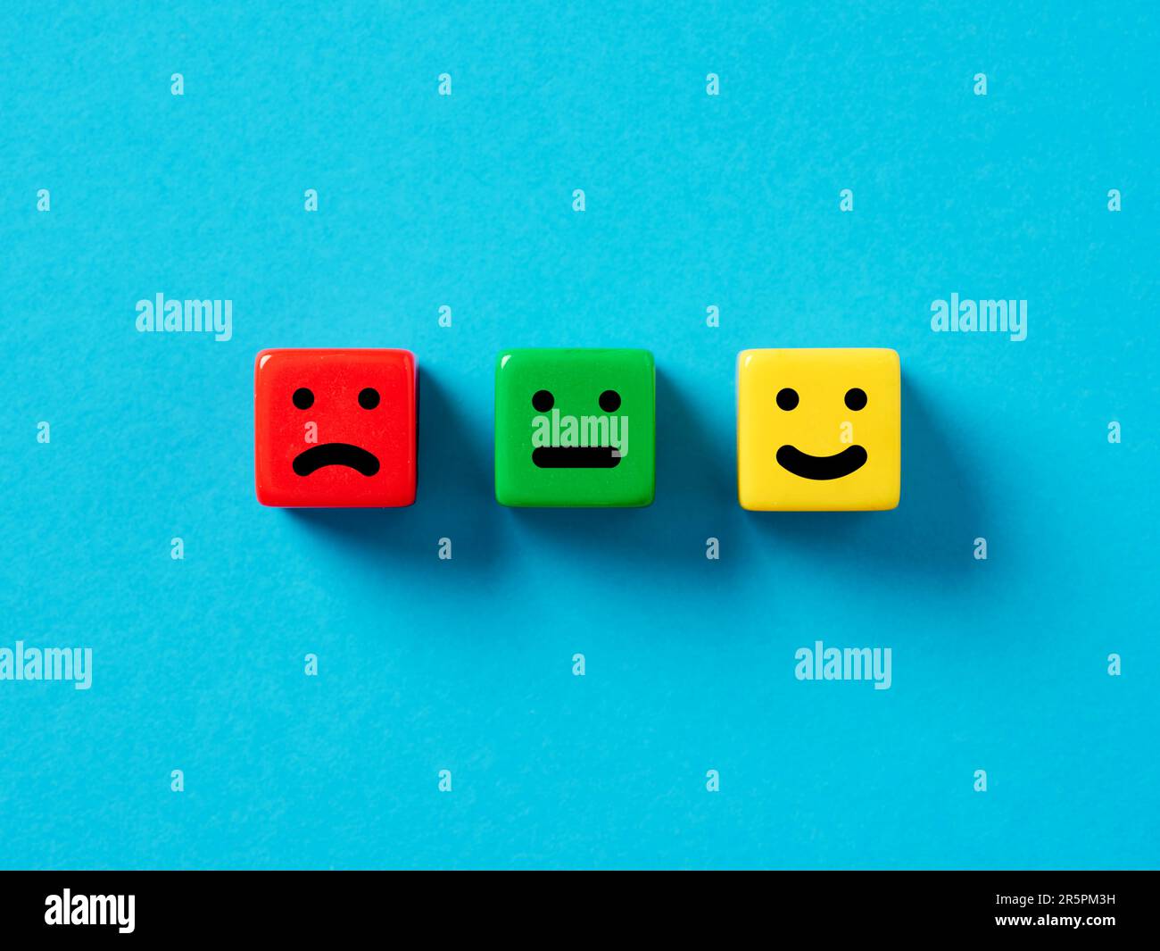 Soddisfazione del cliente, valutazione degli utenti e valutazione del servizio. Faccine emoticon felici e neutre su cubi colorati. Foto Stock