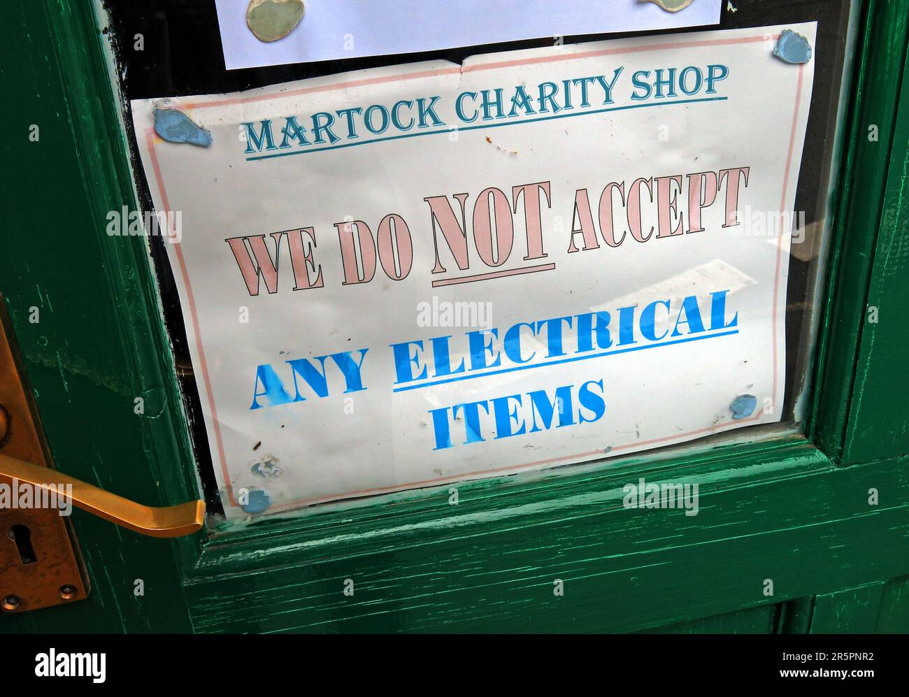 Avviso sulla porta di un negozio di beneficenza a Martock, Somerset, in cui si afferma che gli articoli elettrici non sono accettati per la donazione Foto Stock
