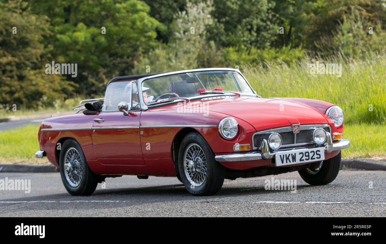Stony Stratford, Regno Unito - Giugno 4th 2023: 1978 Red MG B auto classica in viaggio su una strada di campagna inglese. Foto Stock