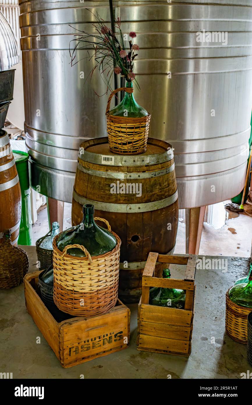 Un'esposizione di contenitori di vino d'annata di fronte a una moderna vasca di fermentazione del vino d'acciaio presso l'azienda vinicola la Abeja, San Rafael, Argentina. La Abeja è il olde Foto Stock