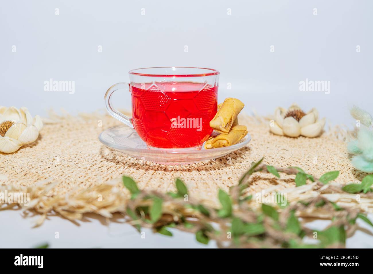 Questa tazza in vetro trasparente consente di apprezzare il colore rosso intenso dello sciroppo contenuto all'interno. Foto Stock