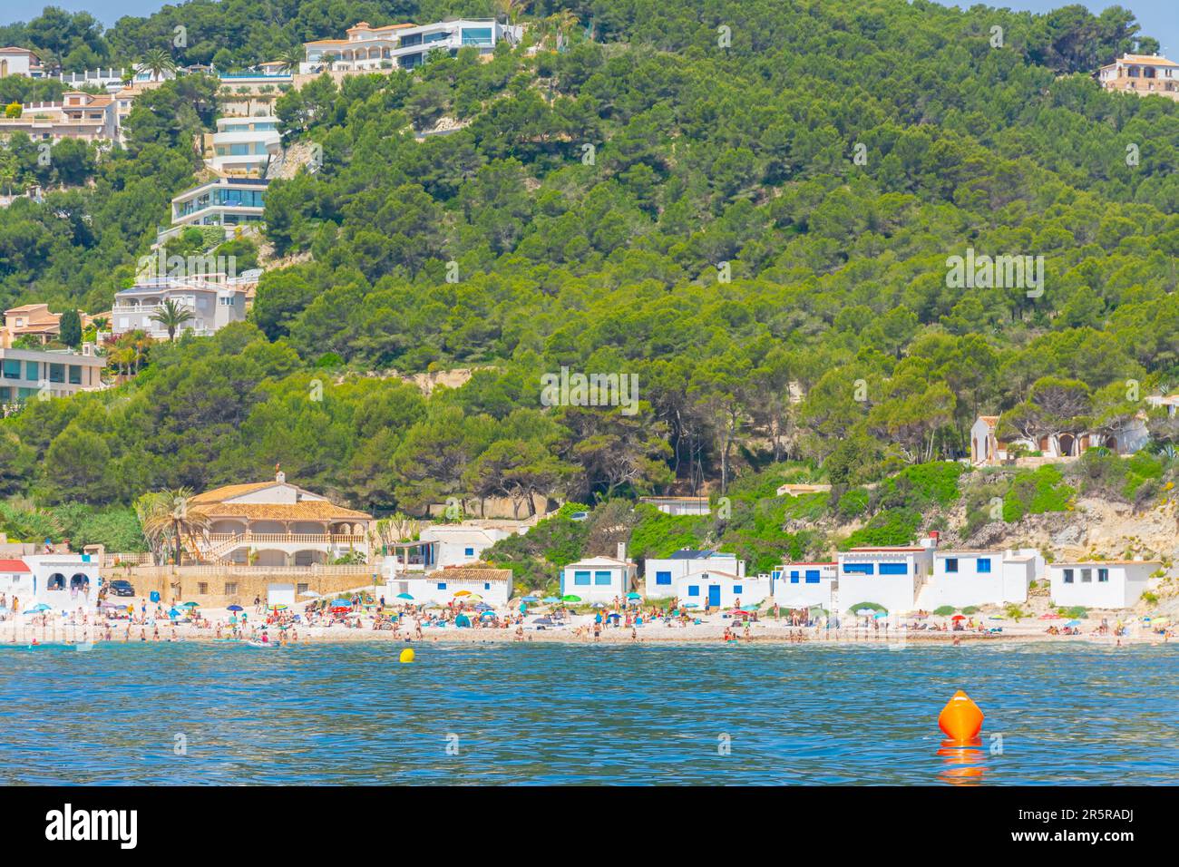 Javea, Alicante, Spagna. 22 maggio 2022 - la baia, Cala Portitxol, una piccola spiaggia con edifici per la pesca e chalet costieri tra i pini sul Foto Stock