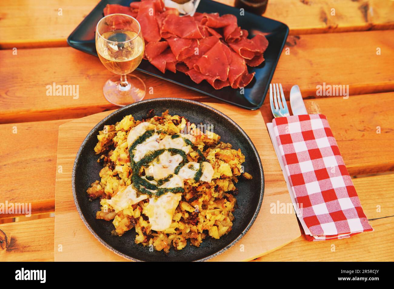 Tradizionale piatto di rosti svizzero con formaggio fuso e pesto di salsa verde, servito con vite bianca e famoso piatto d'incontro freddo vallese Foto Stock