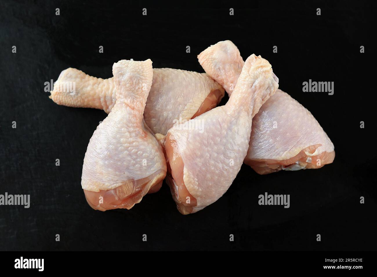 Coscia di pollo crudo sul piatto di pietra Foto Stock