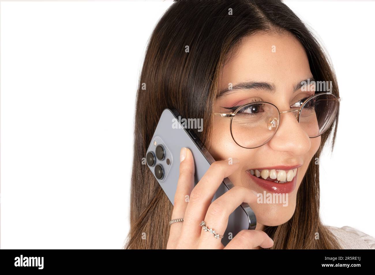 Donna vista laterale ravvicinata che parla al telefono. Attraente donna d'affari caucasica millenaria che possiede un telefono cellulare moderno. Giorno lavorativo del dipendente. Foto Stock