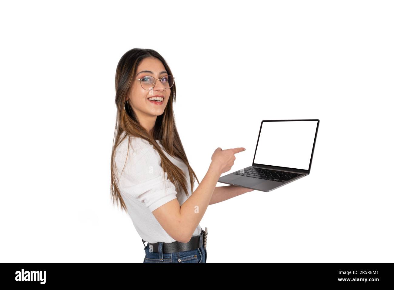 Schermo di puntamento del notebook, ritratto di donna caucasica dei 20 anni che punta lo schermo del notebook. Donna che possiede un moderno notebook con un mockup vuoto per il sito Web Foto Stock