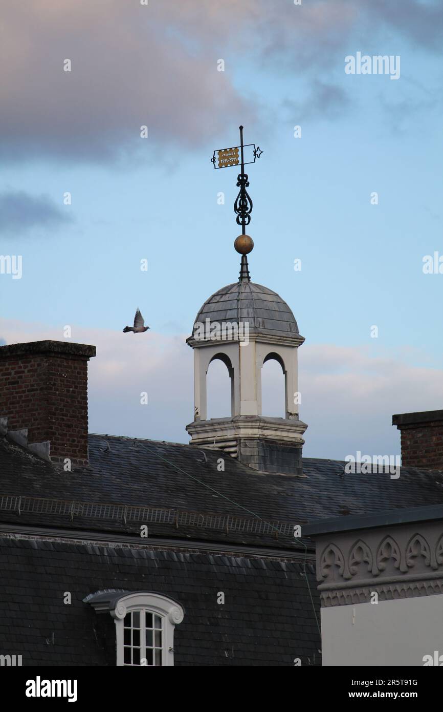 Una classica struttura a due piani con un tetto decorato e indossato dalle intemperie e una pala decorativa in cima ad esso Foto Stock