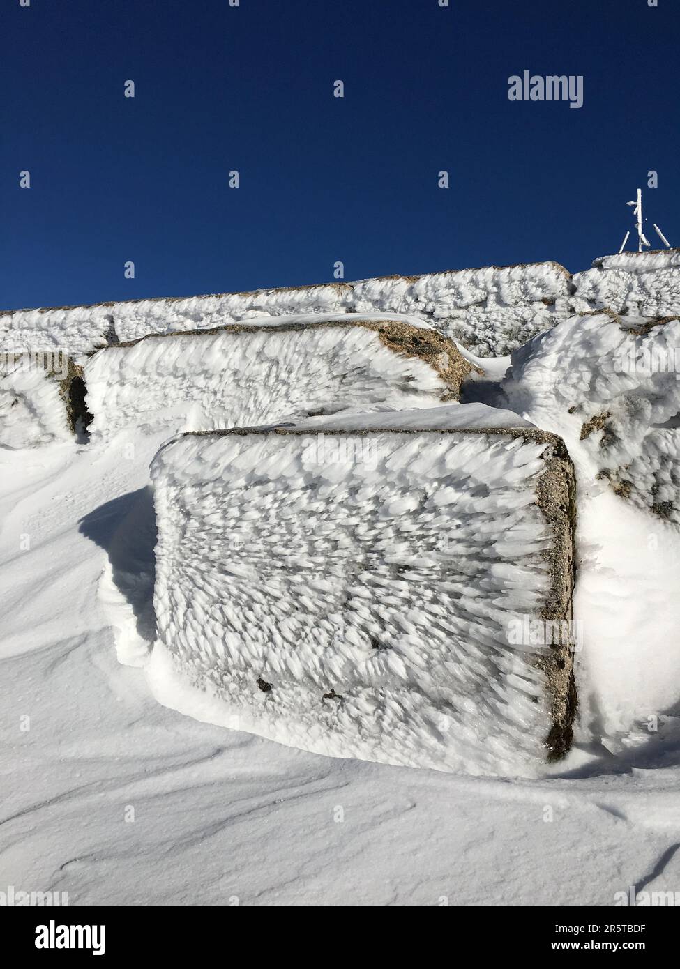 Un colpo verticale di grandi rocce ricoperte di cristalli di ghiaccio e neve a Serra da Estrela, Portogallo Foto Stock