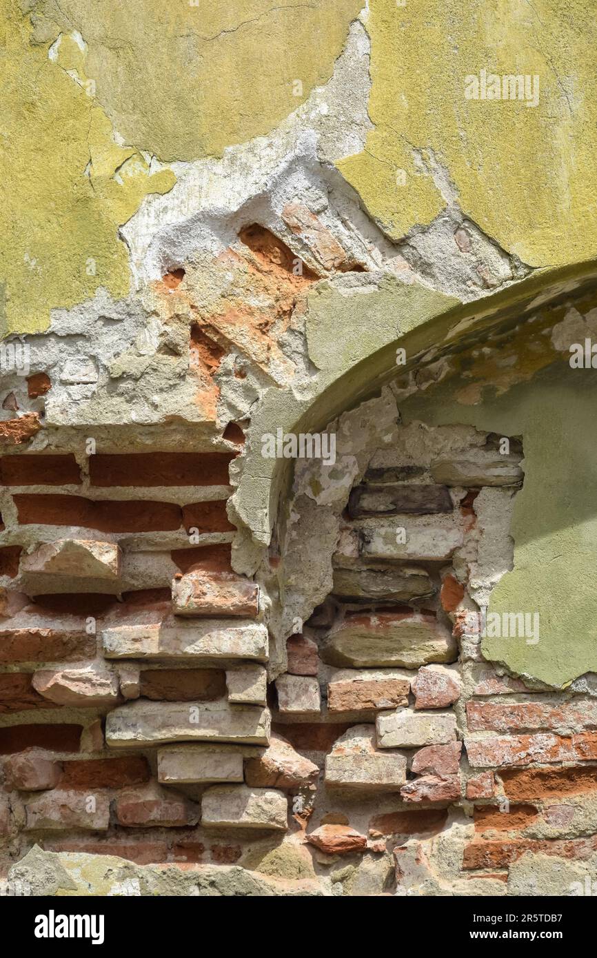 Sfondo di vecchio muro di mattoni gialli con intonaco collassato. Struttura della superficie dell'edificio intatta. Dove è una nicchia arcuata nella parete. Destro Foto Stock